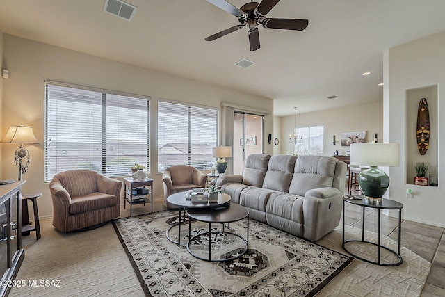 living room featuring visible vents, baseboards, and a ceiling fan