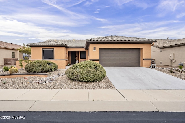 view of front of property with a tile roof, an attached garage, concrete driveway, and stucco siding