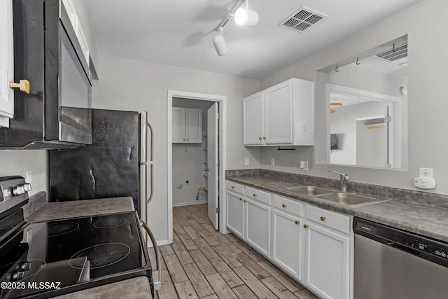 kitchen with wood finish floors, visible vents, a sink, white cabinetry, and stainless steel appliances