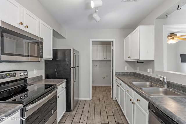 kitchen with light wood-type flooring, a sink, appliances with stainless steel finishes, white cabinets, and ceiling fan