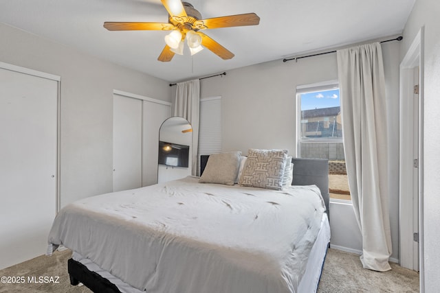 bedroom with baseboards, carpet floors, two closets, and ceiling fan