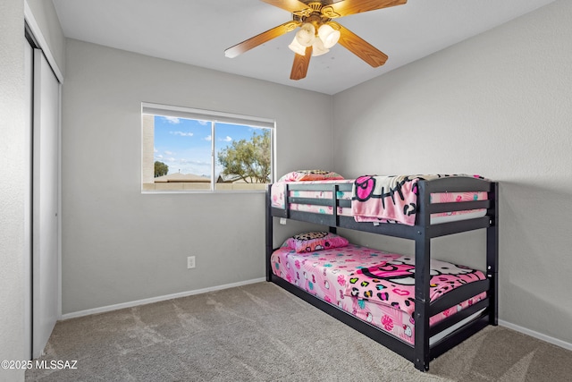 carpeted bedroom with a closet, a ceiling fan, and baseboards