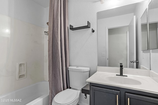 full bathroom featuring vanity, shower / bath combination with curtain, toilet, and a textured wall