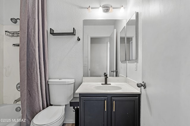 full bath featuring vanity, shower / bath combination with curtain, toilet, and a textured wall