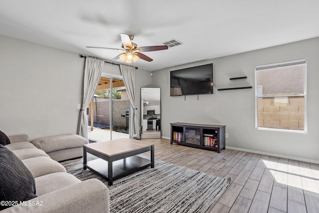 living area featuring ceiling fan, baseboards, visible vents, and wood tiled floor