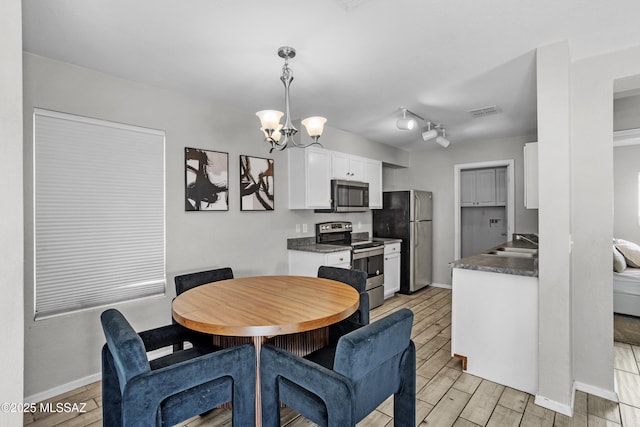 dining area with baseboards, visible vents, a chandelier, and wood tiled floor