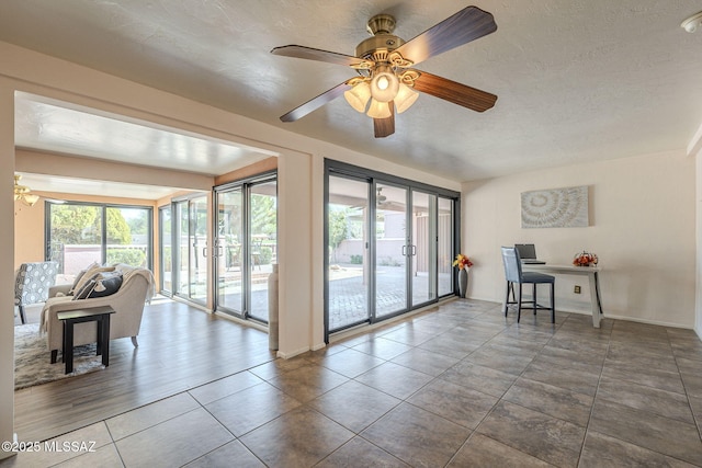 interior space featuring tile patterned flooring, a textured ceiling, and a ceiling fan