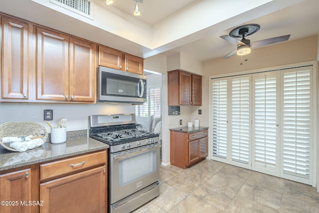 kitchen with visible vents, brown cabinets, stainless steel appliances, and a ceiling fan