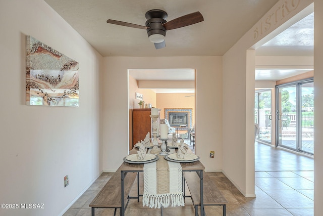 dining space with baseboards and a ceiling fan