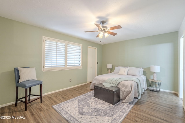 bedroom featuring a ceiling fan, wood finished floors, and baseboards