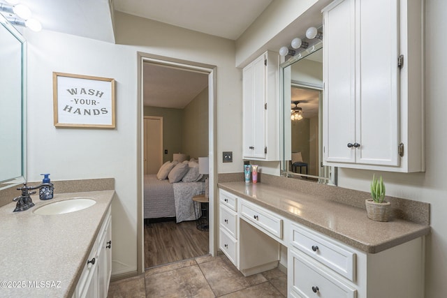 ensuite bathroom with connected bathroom, a ceiling fan, and vanity