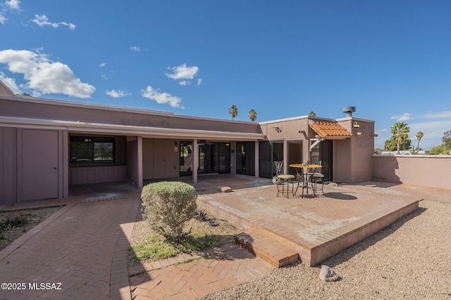 back of house with a patio area and stucco siding