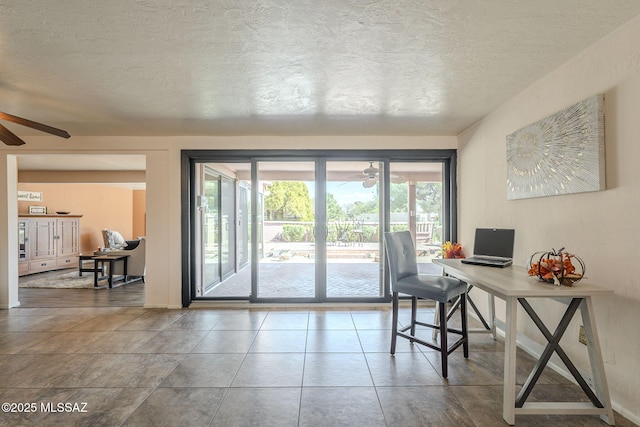 home office featuring tile patterned floors, a ceiling fan, and a textured ceiling