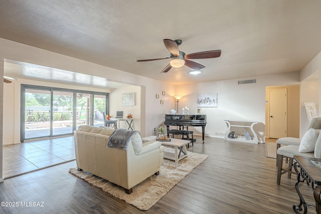 living area featuring visible vents, ceiling fan, and wood finished floors