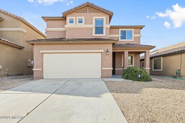 view of front of house with stucco siding, driveway, a tile roof, and a garage