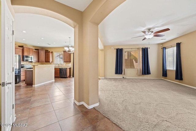 unfurnished room with baseboards, light carpet, plenty of natural light, and ceiling fan with notable chandelier