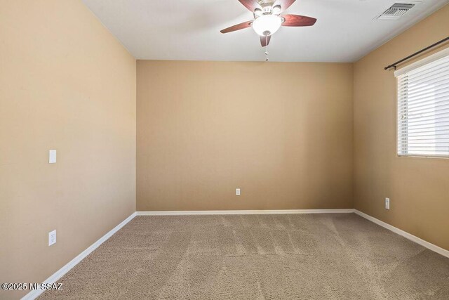 carpeted empty room with a ceiling fan, baseboards, and visible vents