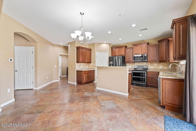 kitchen featuring visible vents, a notable chandelier, a sink, stainless steel appliances, and arched walkways