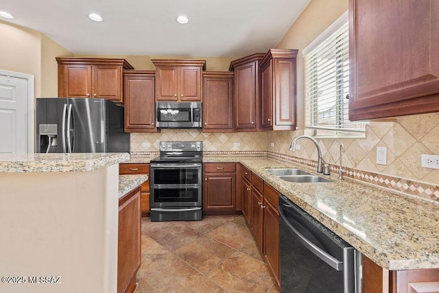 kitchen with light stone counters, recessed lighting, a sink, decorative backsplash, and appliances with stainless steel finishes