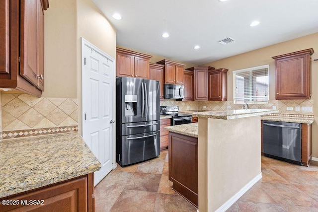 kitchen with light stone countertops, recessed lighting, decorative backsplash, appliances with stainless steel finishes, and a center island