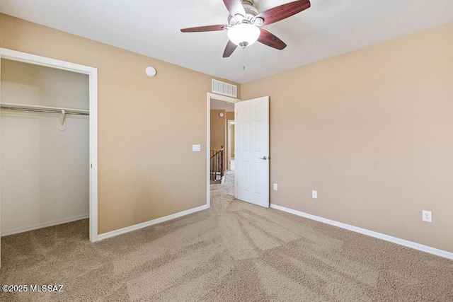 unfurnished bedroom with a closet, visible vents, carpet flooring, a ceiling fan, and baseboards