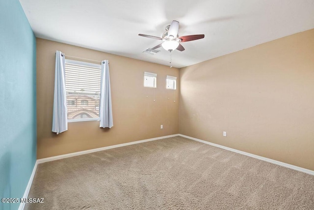 carpeted empty room featuring visible vents, baseboards, and ceiling fan