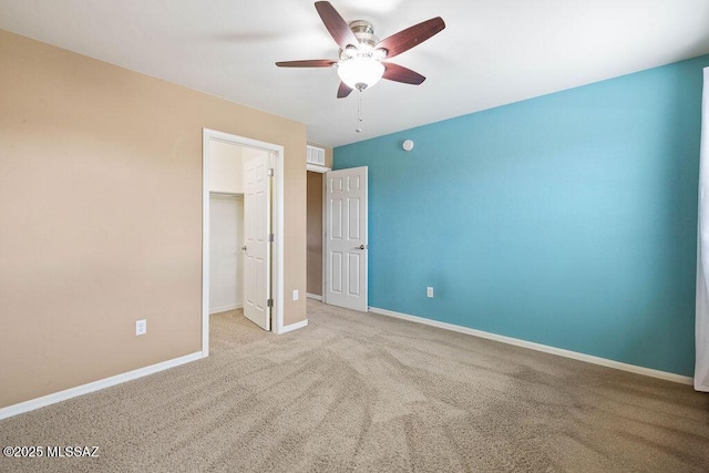 unfurnished bedroom featuring a closet, baseboards, carpet floors, and a spacious closet