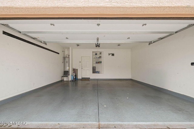 garage with electric water heater, a garage door opener, and baseboards