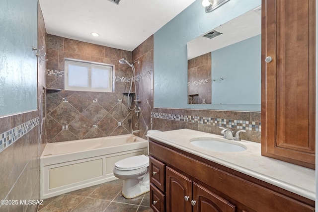 full bath featuring vanity, bathtub / shower combination, tile patterned flooring, tile walls, and toilet