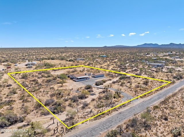 drone / aerial view featuring view of desert, a rural view, and a mountain view
