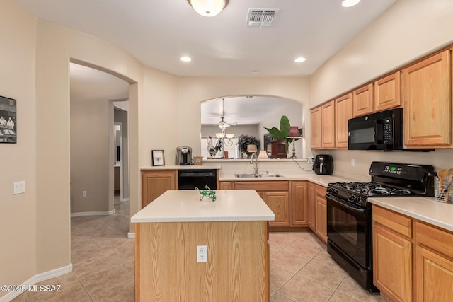 kitchen featuring light tile patterned floors, visible vents, a kitchen island, a sink, and black appliances