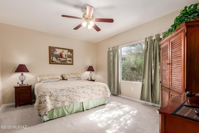 bedroom with light carpet, ceiling fan, and baseboards