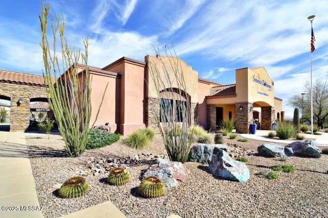 view of front facade featuring stone siding and stucco siding