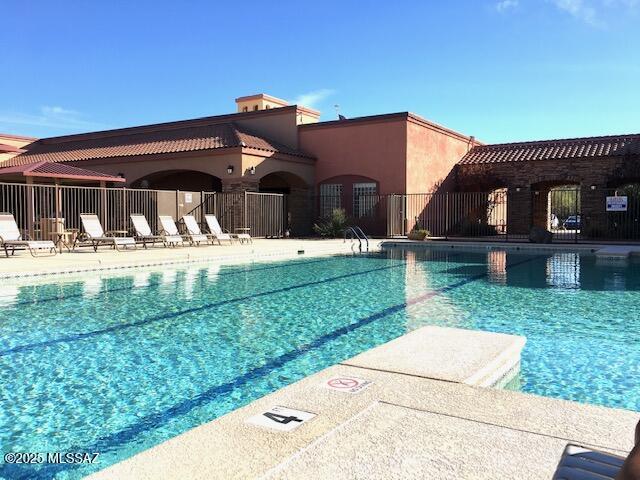 pool with a patio area and fence