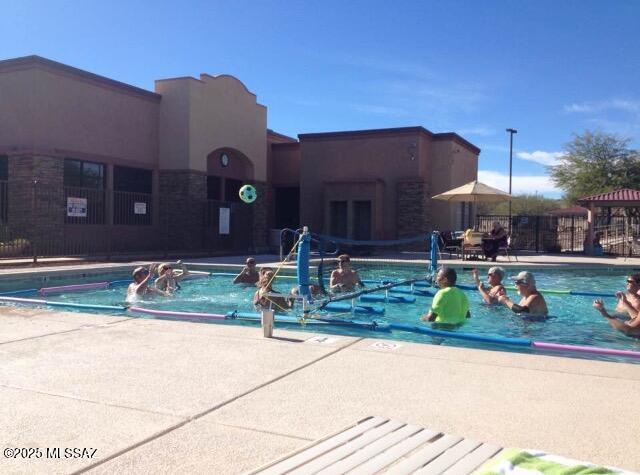 community pool featuring a patio area and fence