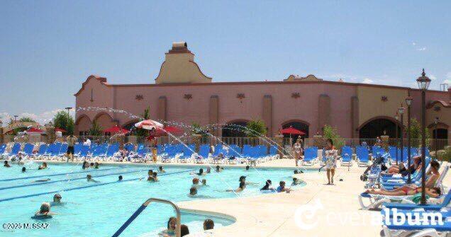 community pool with a patio area and fence