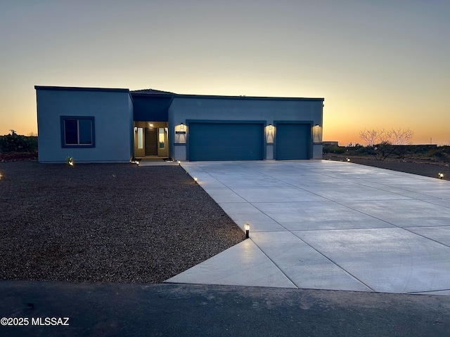 view of front of property featuring a garage, driveway, and stucco siding