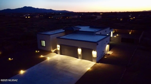 view of front of home featuring concrete driveway, a jacuzzi, and a mountain view