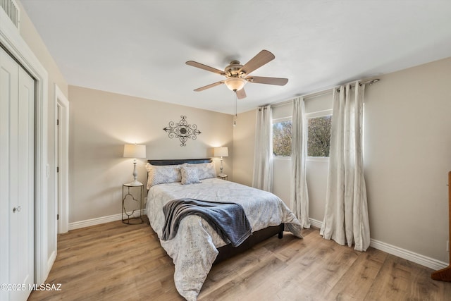 bedroom featuring visible vents, a closet, light wood finished floors, baseboards, and ceiling fan