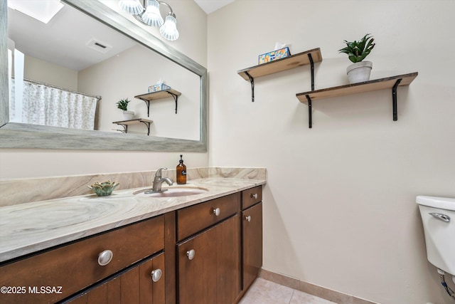 bathroom featuring visible vents, toilet, a skylight, tile patterned floors, and vanity