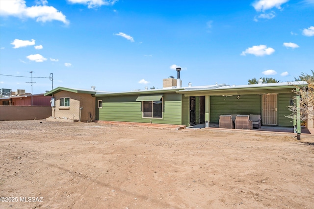 back of property with a patio area, brick siding, and a chimney