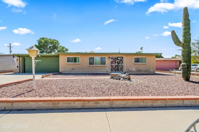 single story home with brick siding, an attached garage, and concrete driveway