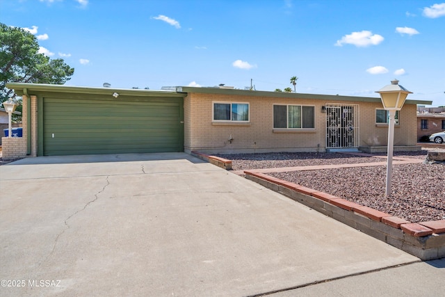 ranch-style home featuring brick siding, an attached garage, and driveway