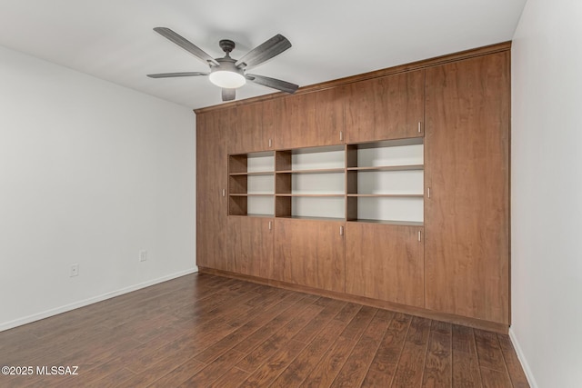 empty room featuring baseboards, a ceiling fan, and dark wood-style flooring