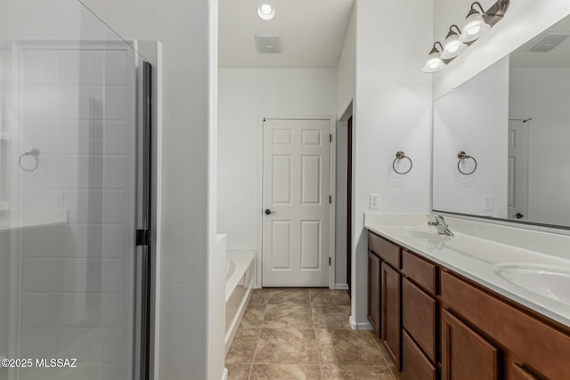 full bathroom featuring a garden tub, double vanity, visible vents, and a sink