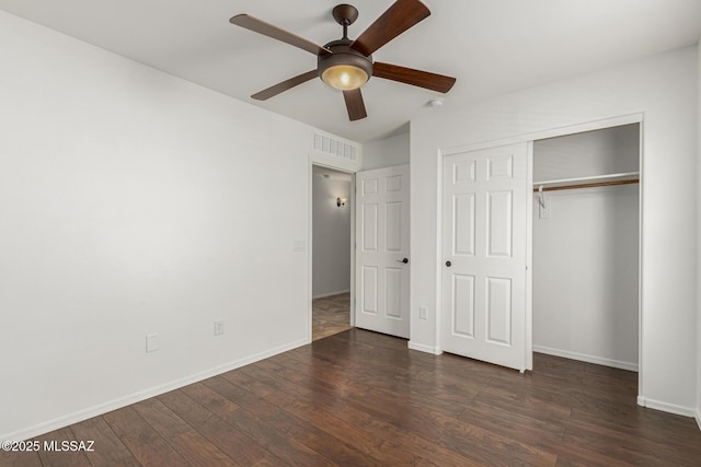 unfurnished bedroom featuring wood finished floors, visible vents, a closet, and baseboards