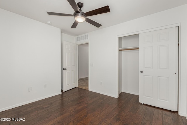 unfurnished bedroom featuring dark wood-style floors, visible vents, a closet, and baseboards