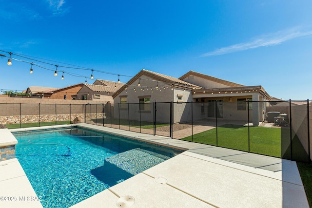 view of swimming pool with a yard, a fenced in pool, a patio, and a fenced backyard