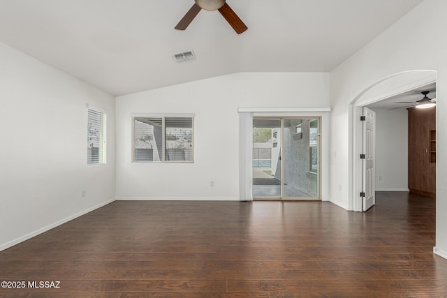 empty room with visible vents, wood finished floors, baseboards, ceiling fan, and vaulted ceiling