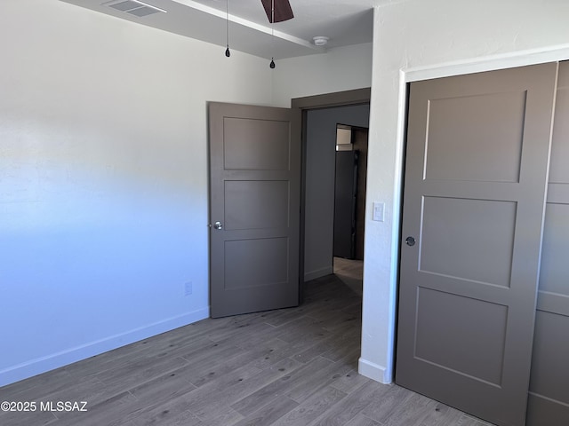 unfurnished bedroom featuring visible vents, wood finished floors, and baseboards